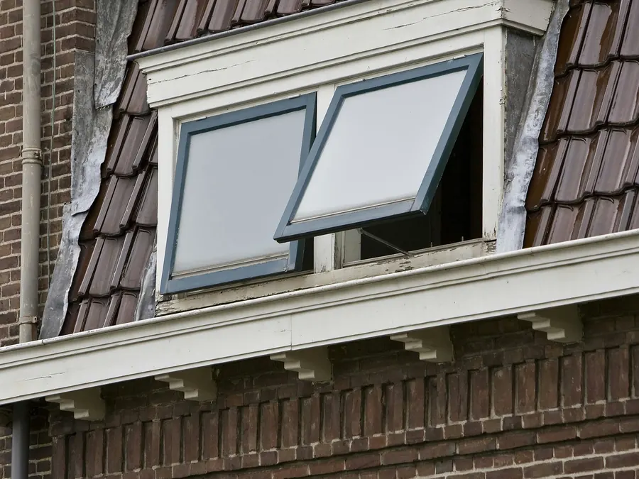 Dakkapel met witte kroonlijst, gootklossen en geglazuurde pannen, detail van zorgvuldig dakwerk